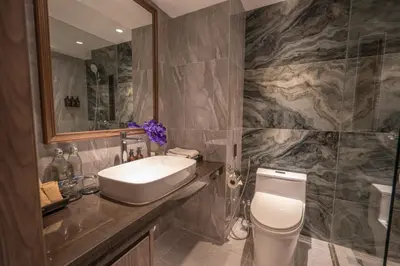 a bathroom with a sink and a toilet and a mirror at NH Bangkok Sukhumvit Boulevard in Bangkok