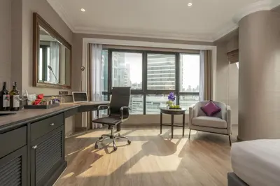 a hotel room with a bed and a desk and chair at NH Bangkok Sukhumvit Boulevard in Bangkok