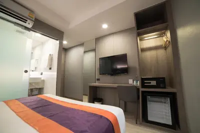 a hotel room with a bed and a tv at Studio Ekamai in Bangkok