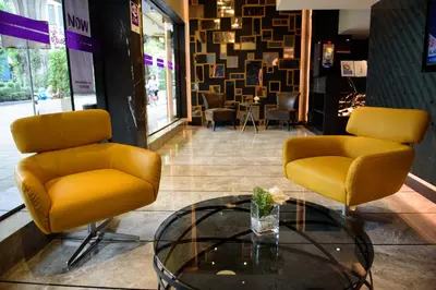 a lobby with two chairs and a glass table at Studio Ekamai in Bangkok