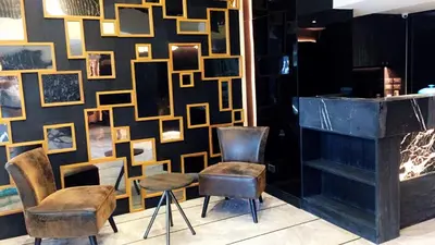 a room with two chairs and a wall with pictures at Studio Ekamai in Bangkok