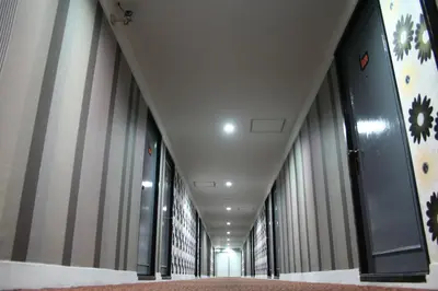 an empty hallway of a building with tall windows at Baiyoke Boutique Hotel in Bangkok