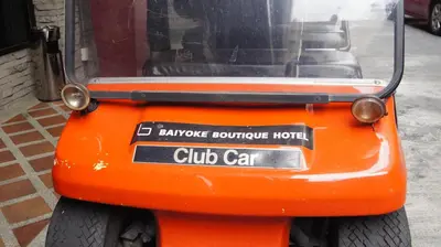 an orange golf cart parked on a street at Baiyoke Boutique Hotel in Bangkok