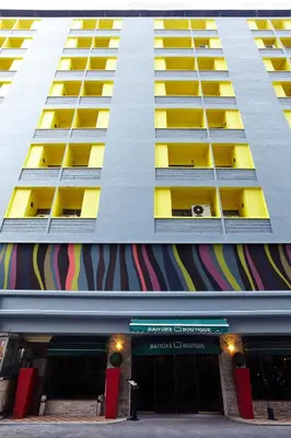 a tall building with yellow windows and a store at Baiyoke Boutique Hotel in Bangkok
