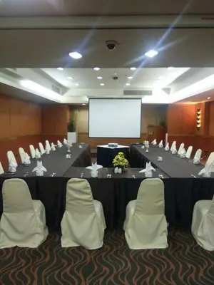a conference room with a table and chairs and a screen at Tai Pan Hotel in Bangkok