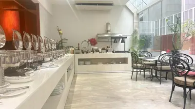 a room with a counter with chairs and a table at Tai Pan Hotel in Bangkok