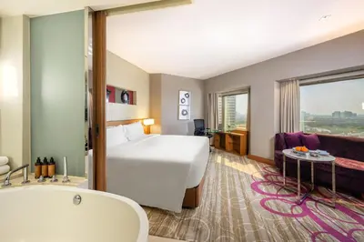 a hotel room with a bed and a bath tub at Centara Grand at Central Plaza Ladprao Bangkok in Bangkok