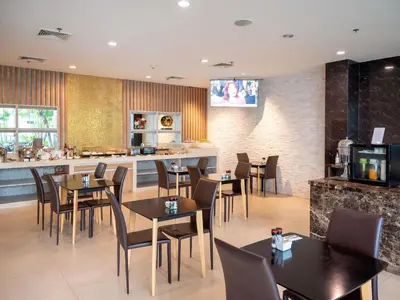 a restaurant with tables and chairs and a bar at Grand Mercure Bangkok Asoke Residence in Bangkok