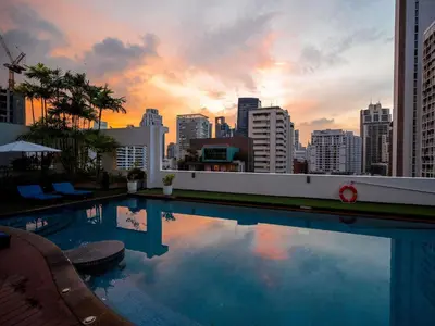 a swimming pool with a city skyline in the background at Grand Mercure Bangkok Asoke Residence in Bangkok