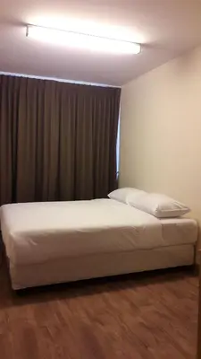 a bed sitting in a room with a window at The Blooms Residence in Bangkok