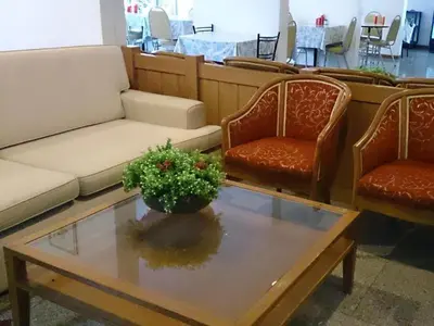 a living room with a couch and two chairs and a table at The Blooms Residence in Bangkok