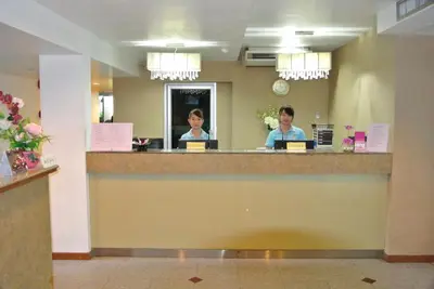 two people sitting at a reception counter in a hotel room at The Blooms Residence in Bangkok