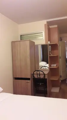 a room with a bed and a desk and a kitchen at The Blooms Residence in Bangkok