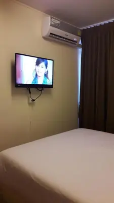 a bedroom with a bed and a television on a wall at The Blooms Residence in Bangkok