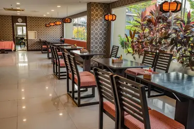 a row of tables and chairs in a restaurant at Boss Suites Nana Hotel in Bangkok
