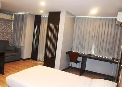 a bedroom with a bed and a couch and a desk at YWCA Hotel Bangkok in Bangkok
