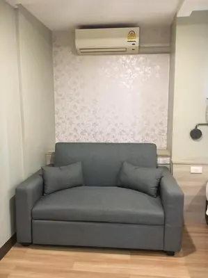 a couch in a living room with a ceiling fan at YWCA Hotel Bangkok in Bangkok