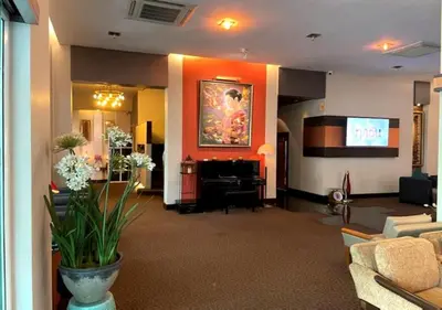 a lobby with a living room with a piano at Atrium Boutique Hotel in Bangkok