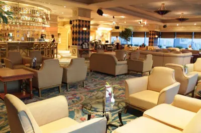 a lobby of a hotel with chairs and a bar at Golden Tulip Sovereign Hotel Bangkok in Bangkok