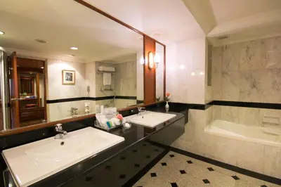 a bathroom with two sinks and a bath tub at Golden Tulip Sovereign Hotel Bangkok in Bangkok