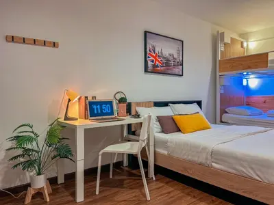 a bedroom with a bed and a desk with a computer at Click Hostel in Bangkok