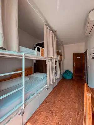 a room with bunk beds and a wooden floor at Click Hostel in Bangkok