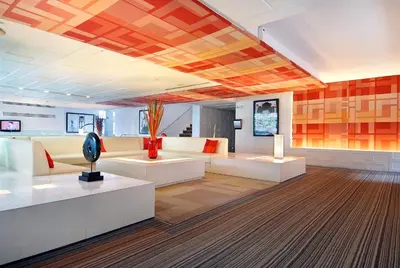 a living room with white furniture and orange walls at Le Fenix Sukhumvit 11 Bangkok in Bangkok