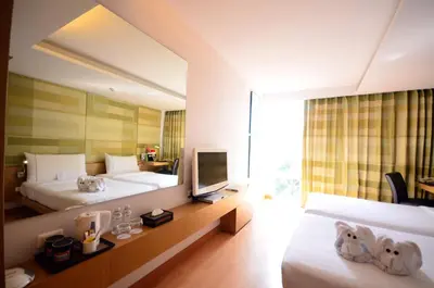 a hotel room with two beds and a television at Le Fenix Sukhumvit 11 Bangkok in Bangkok