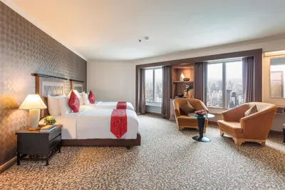 a large hotel room with a bed and a chair at Baiyoke Sky Hotel in Bangkok