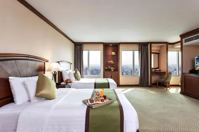 a hotel room with two beds and a television at Baiyoke Sky Hotel in Bangkok