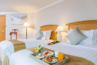 a hotel room with two beds with a tray of food at Baiyoke Sky Hotel in Bangkok