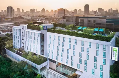an apartment building with a green roof at Holiday Inn Express Bangkok Soi Soonvijai by IHG in Bangkok