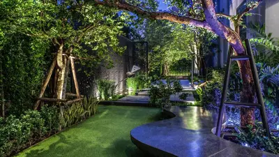 a garden with green grass and trees and ladders at Holiday Inn Express Bangkok Soi Soonvijai by IHG in Bangkok