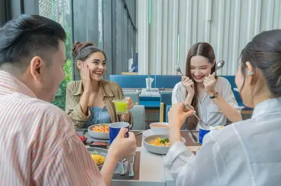 a group of people sitting around a table eating food at Holiday Inn Express Bangkok Soi Soonvijai by IHG in Bangkok