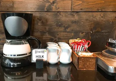 a group of milk jars sitting next to a coffee maker at Fraser Suites Sukhumvit Bangkok in Bangkok