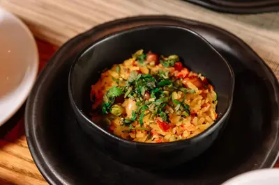 a black bowl of food on a black plate at Fraser Suites Sukhumvit Bangkok in Bangkok