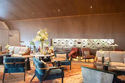 a lobby with tables and chairs and a couch at Fraser Suites Sukhumvit Bangkok in Bangkok