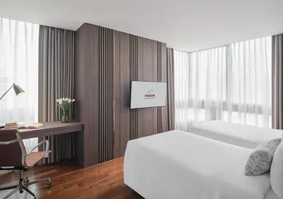 a bedroom with a bed and a desk with a computer at Fraser Suites Sukhumvit Bangkok in Bangkok