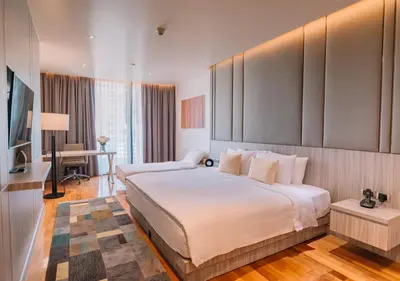 a hotel room with a large bed and a desk at Fraser Suites Sukhumvit Bangkok in Bangkok