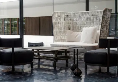 a living room with a couch and two chairs and a table at COMO Metropolitan Bangkok in Bangkok