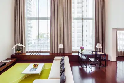 a living room with a couch and a table at COMO Metropolitan Bangkok in Bangkok