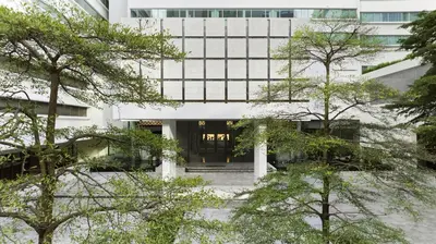 an office building with trees in front of it at COMO Metropolitan Bangkok in Bangkok