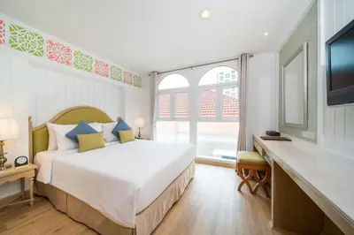 a bedroom with a large bed and a television at La Petite Salil Sukhumvit 8 in Bangkok