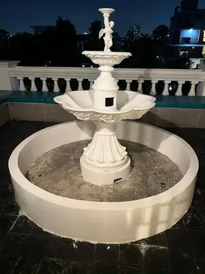 a white fountain in the middle of a courtyard at V20 Boutique Jacuzzi Hotel in Bangkok