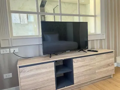 a flat screen tv sitting on top of a wooden entertainment center at V20 Boutique Jacuzzi Hotel in Bangkok