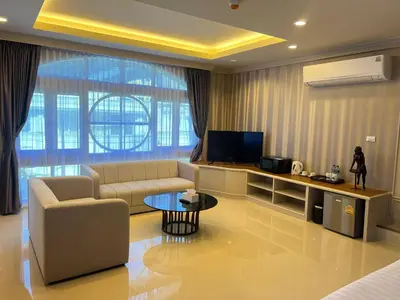 a living room with a couch and a tv at V20 Boutique Jacuzzi Hotel in Bangkok