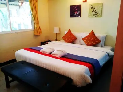 a bedroom with two beds with pink pillows on them at Sawasdee Sukhumvit Inn in Bangkok