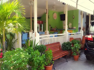 a restaurant with benches and plants in front of it at Sawasdee Sukhumvit Inn in Bangkok