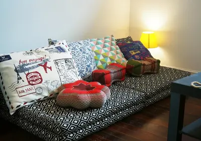 a couch with many pillows on it in a room at The Serene House Bangkok in Bangkok