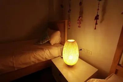 a bedroom with a bed and a lamp on a table at The Serene House Bangkok in Bangkok